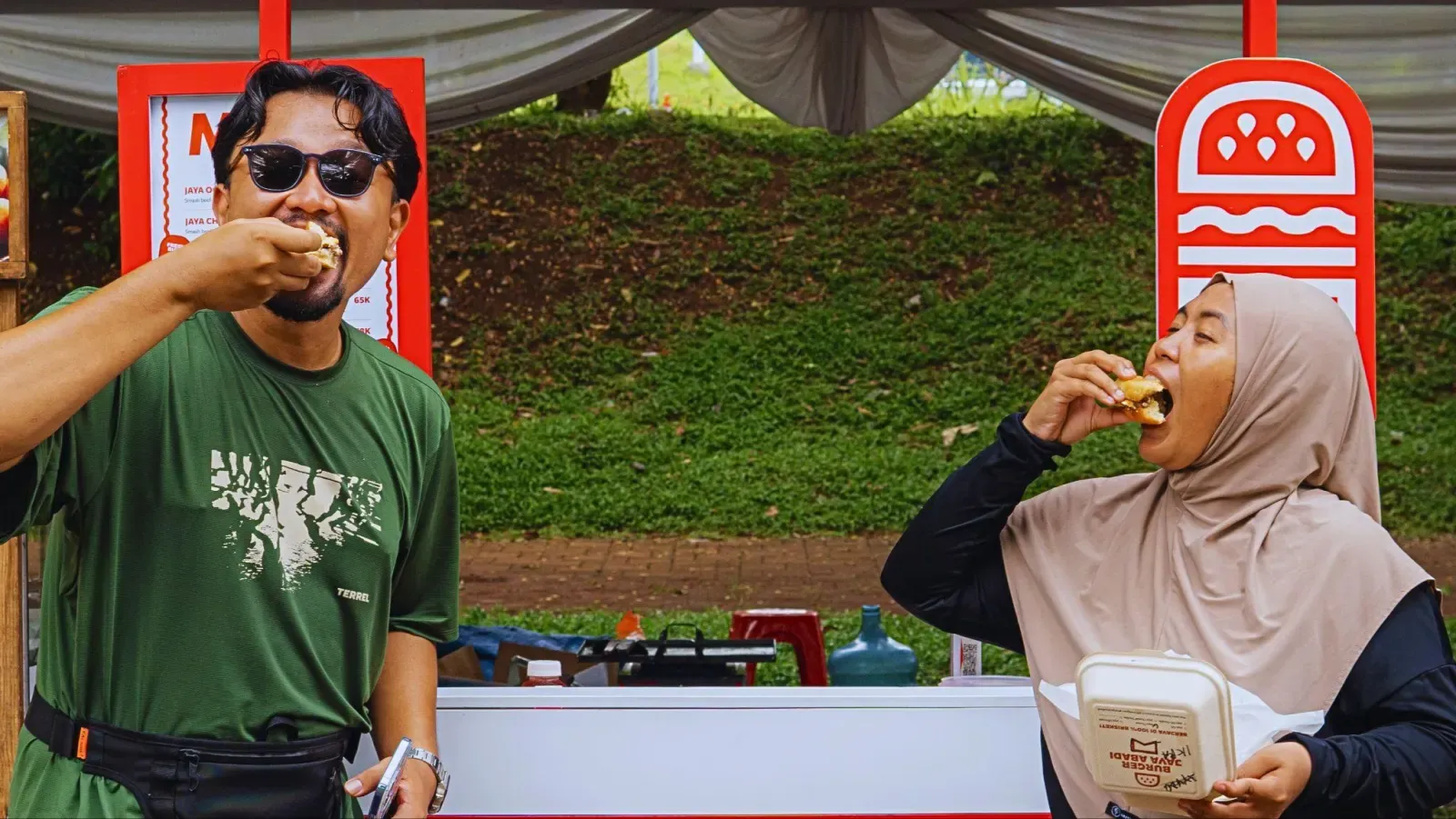 Pengunjung menikmati burger di depan booth Burger Jaya Abadi